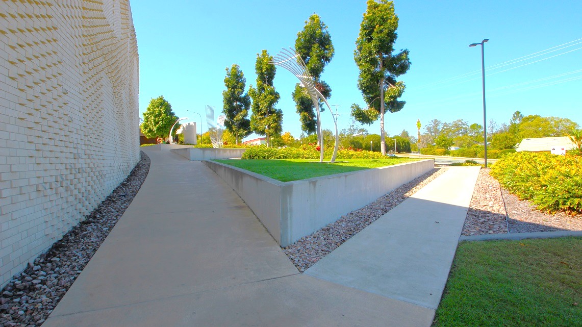 A closer look at one of the pathways of the Gympie ARC. The pathway has meticulously maintained white surfaces, radiating a sense of cleanliness and order. On either side of the path, you'll find dozens of small rocks thoughtfully arranged, serving both an aesthetic and functional purpose.