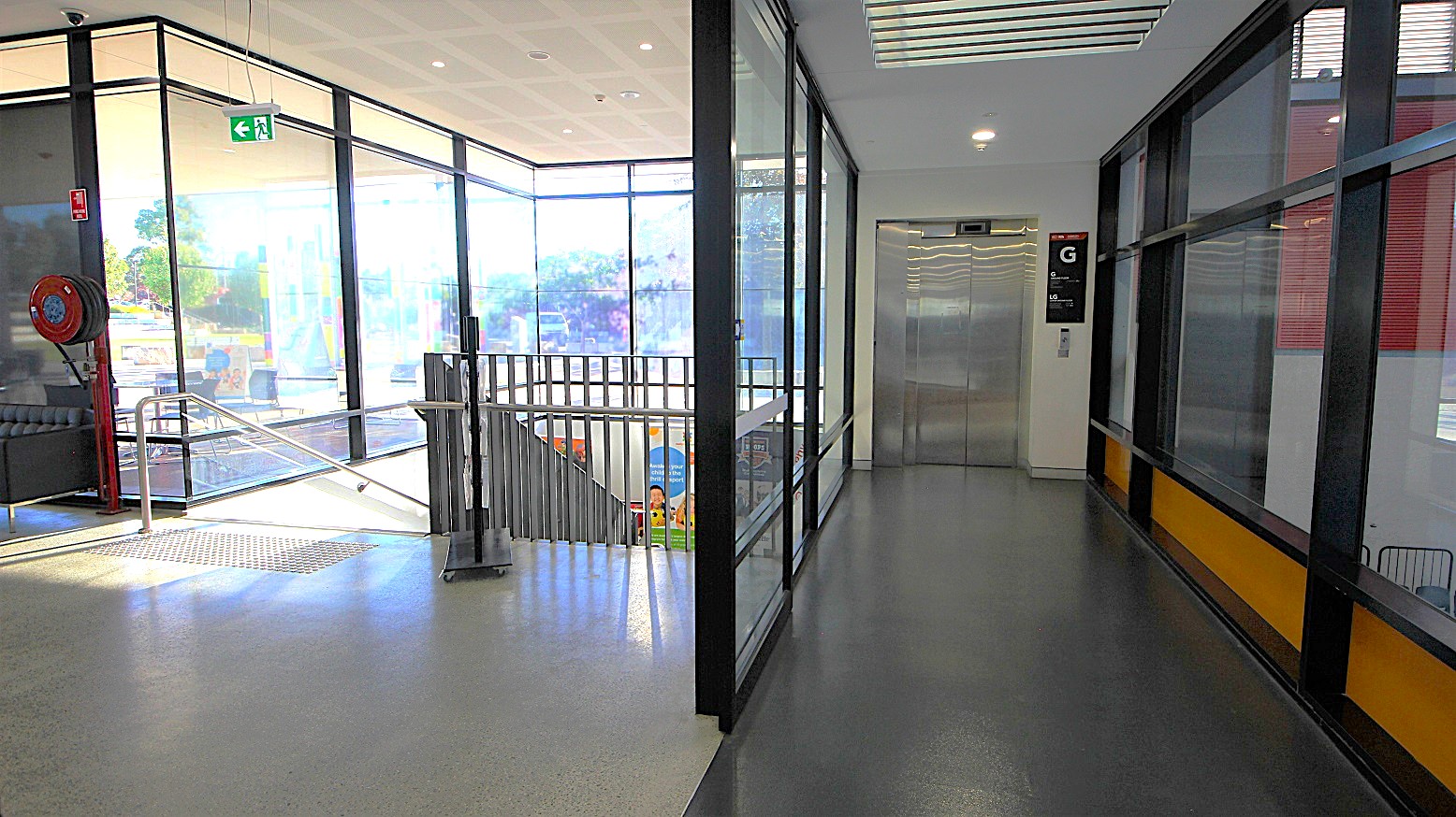 Elevator access to the gym and multipurpose rooms at the Michael Clarke Recreation. It can be distinguished by the black floor right beside the black stairwell access. On the upper right of the elevator are Ground (G) and Lower Ground (G) labels. At the middle of the topmost of the elevator doors is the display screen where you can track which floor the elevator is currently on.
