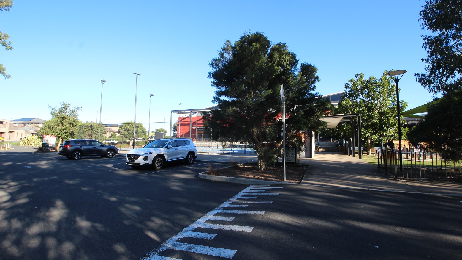 Cars are parked in the extra parking space available at the bottom of the hill and next to the tennis courts. There is also free step access from the parking space that protects the guests from direct sunlight. White road markings with different heights are painted to alert drivers of a vertical curve ahead.